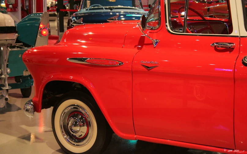 red car in display on floor next to other cars