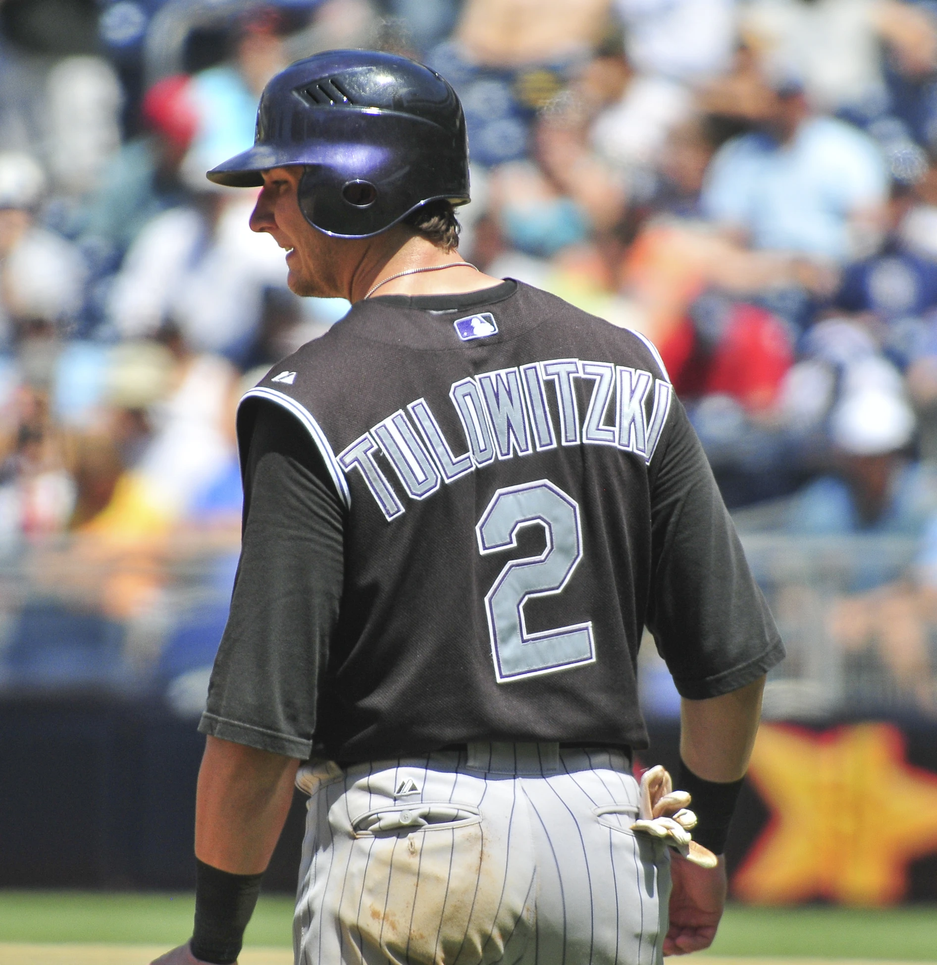 the professional baseball player is holding his bat and looking back