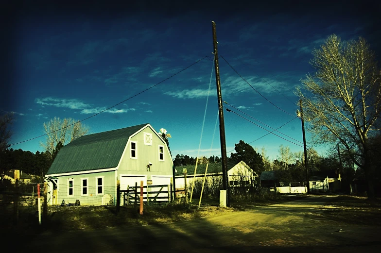 an old white farm house with power lines