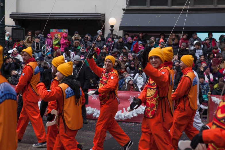 a group of people wearing orange clothing standing on the street