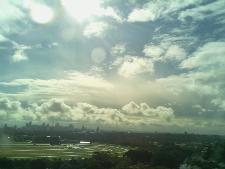 sun peeking out of the clouds over the city