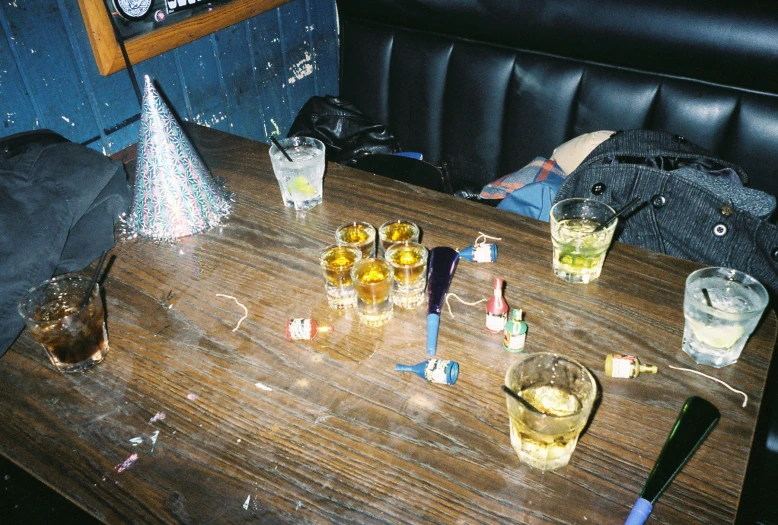 a wooden table topped with glasses filled with liquor
