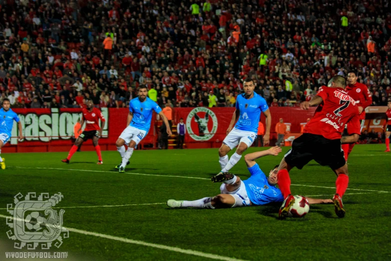 a group of soccer players playing soccer against each other