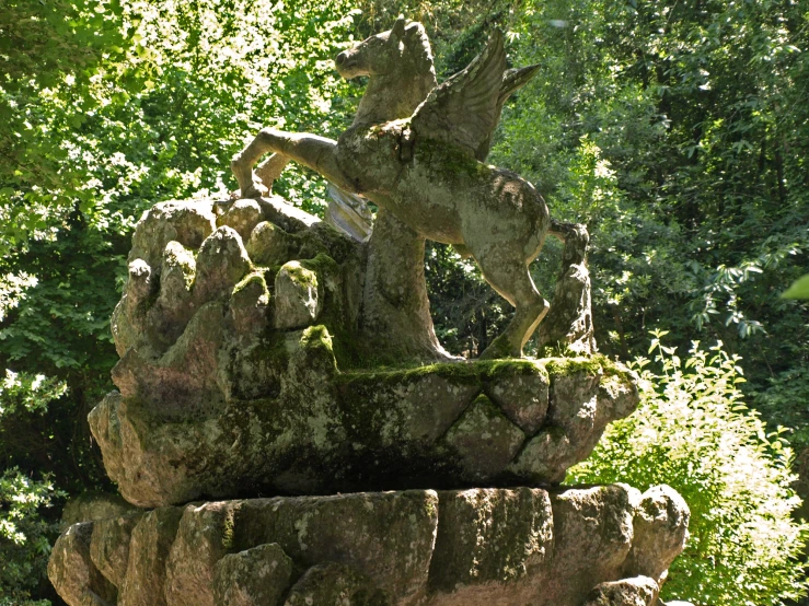 a stone sculpture is in the middle of the forest