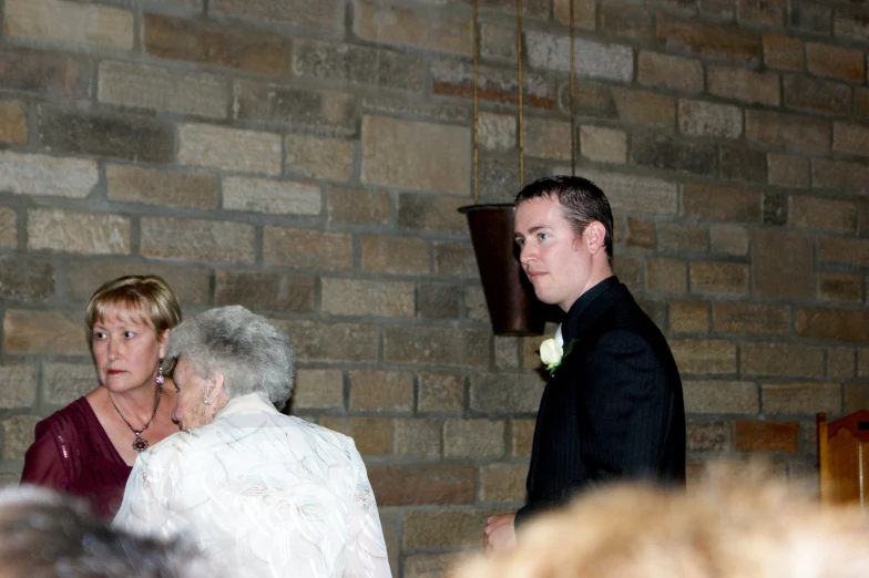 a young woman and an older man standing in front of a brick wall