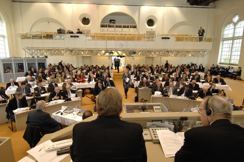 a crowd of people are gathered to take notes and talk at tables