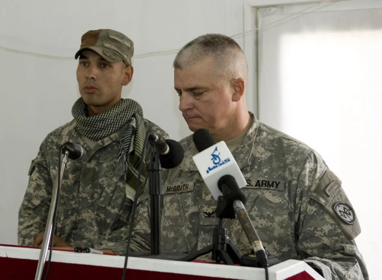 two military men standing in front of microphones next to each other