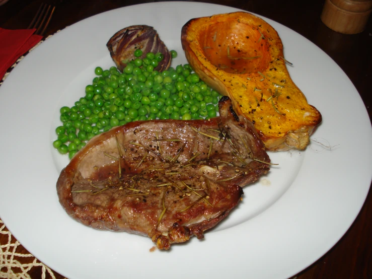 a plate that has food on it including peas and meat