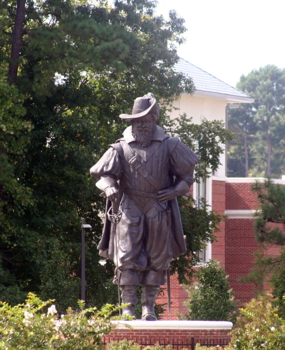 the statue is wearing a hat and trench coat