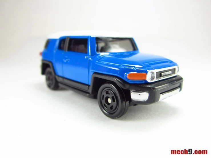 a toy blue pickup truck with white top