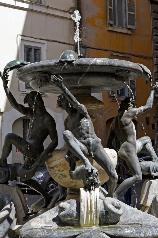 two statues hold onto the same object as they stand in the fountain