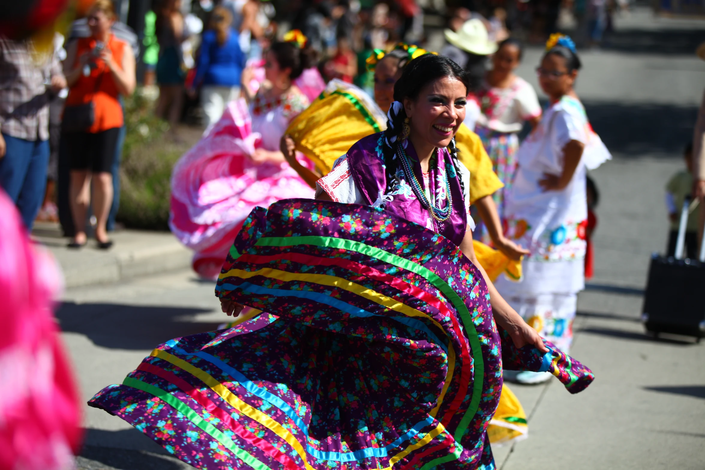 woman walking on side walk with various colored clothing and head piece