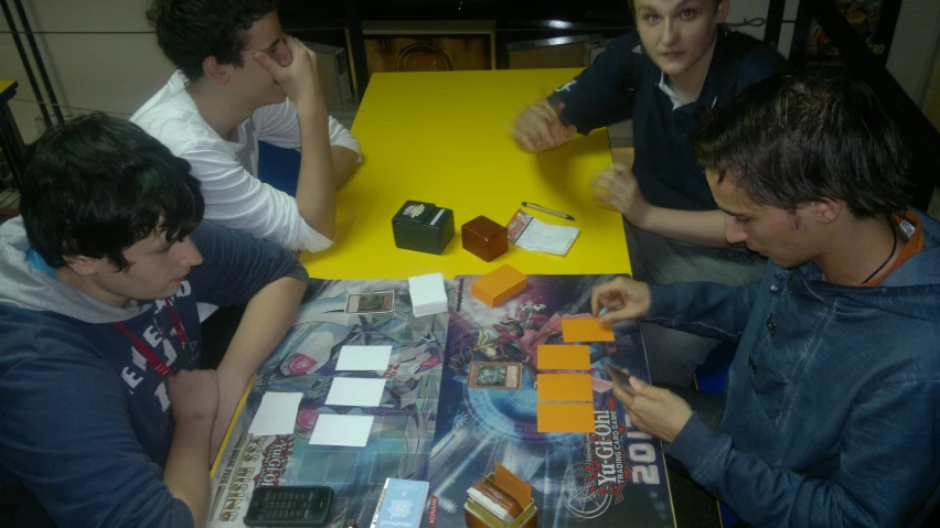 four guys at a table playing an exciting game