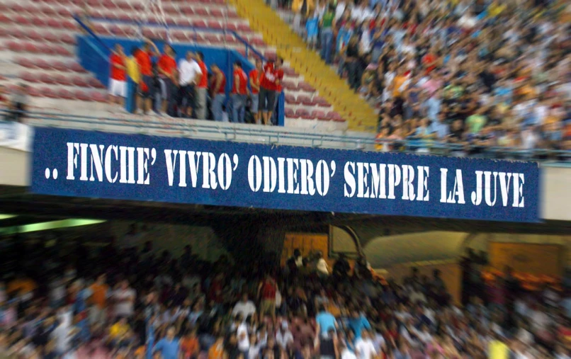 there is a large blue sign hanging from a stadium wall