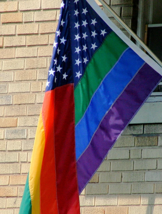 a rainbow flag in front of a brick building