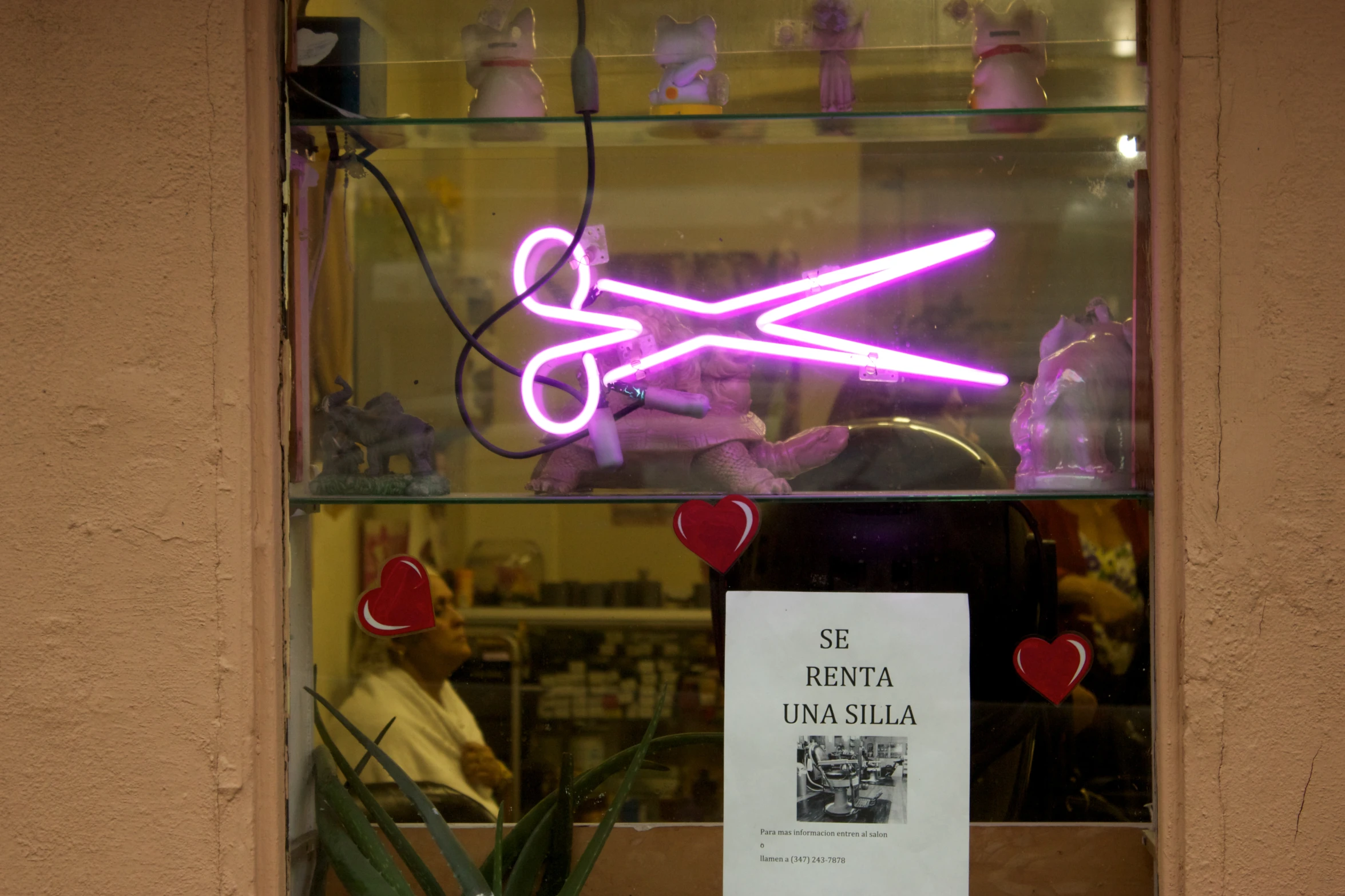 a neon sign in a window, stating it's time to cut the ribbon