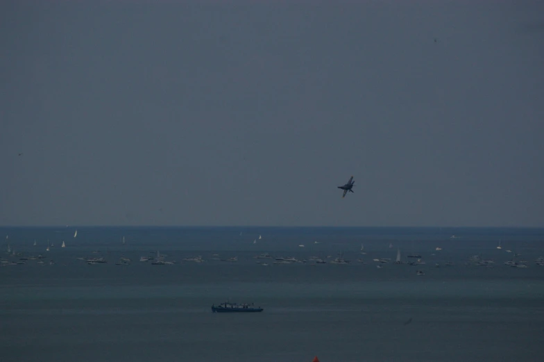 an airplane flying over the water with lots of boats