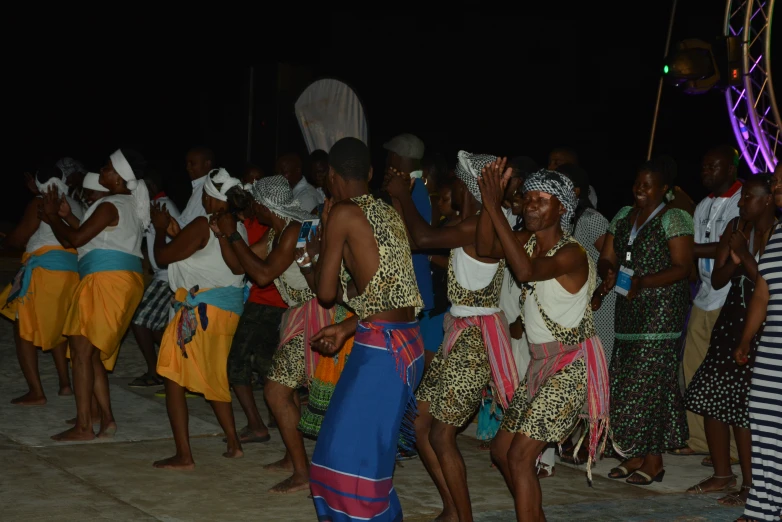 a large group of people in native garb dancing