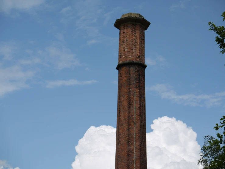 a brick tower with a flag on top in the clouds