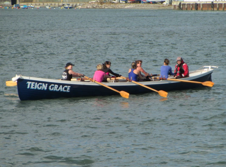 people are on a blue boat with yellow oars