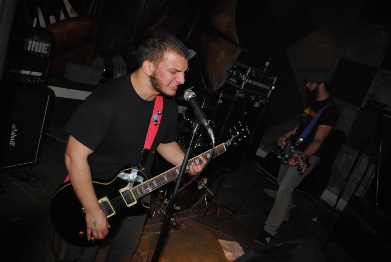 a man in black shirt playing an electric guitar