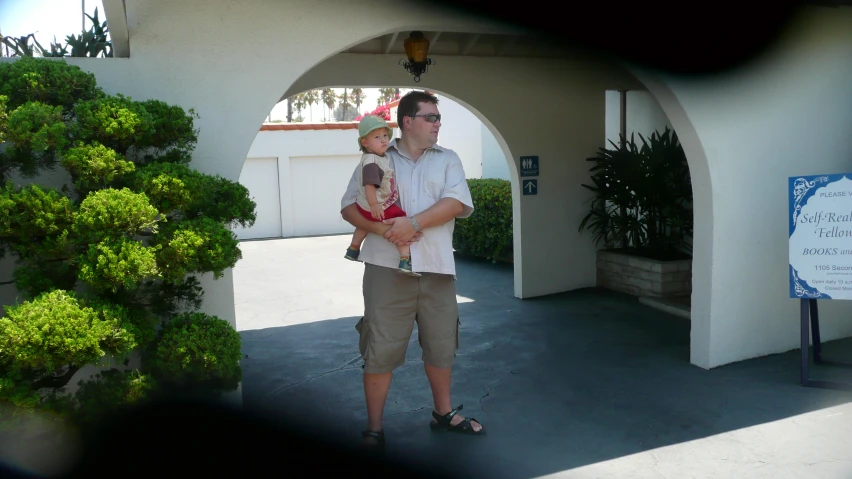 a man and his child are standing in front of a building