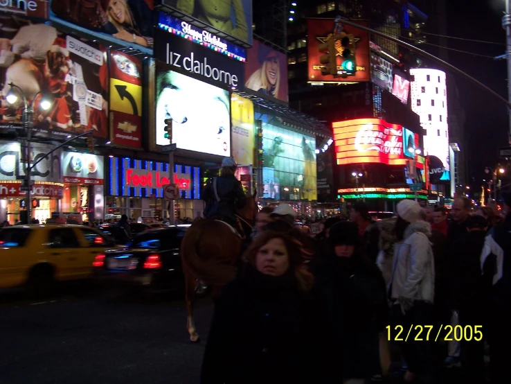 a street filled with people and traffic at night