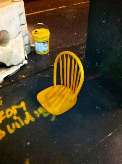 a wooden chair and buckets on the sidewalk