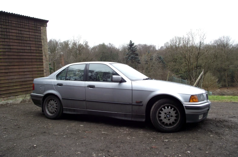 a grey car is parked next to a building