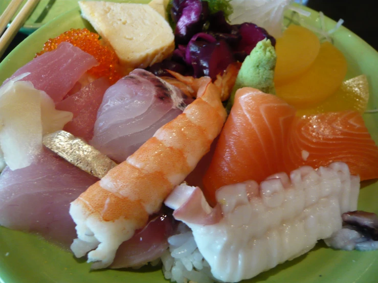 a plate of sashimi in an assortment of colorful flavors