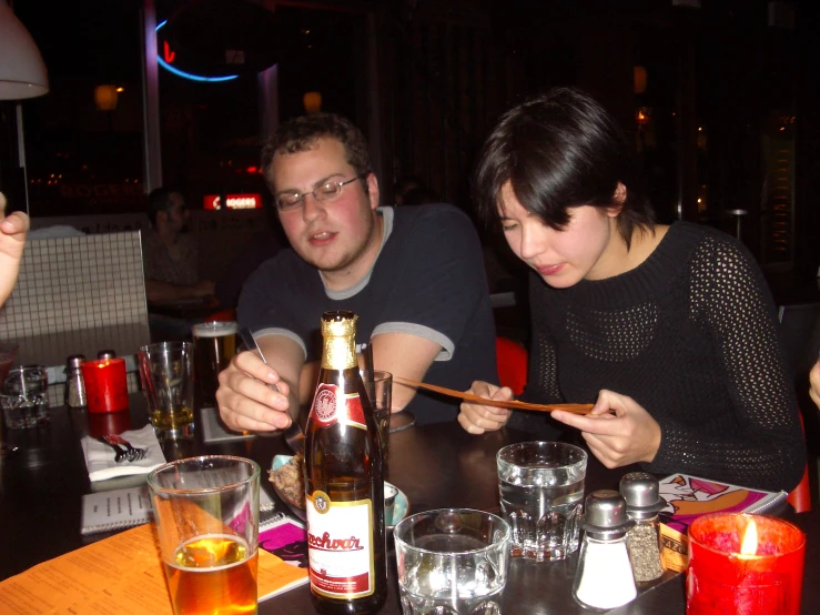 two people eating sushi in an asian restaurant