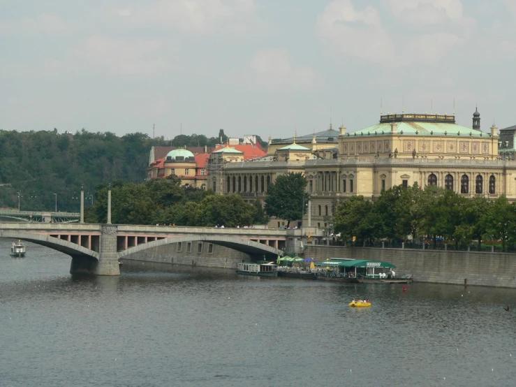 a couple boats traveling down the water towards a large building