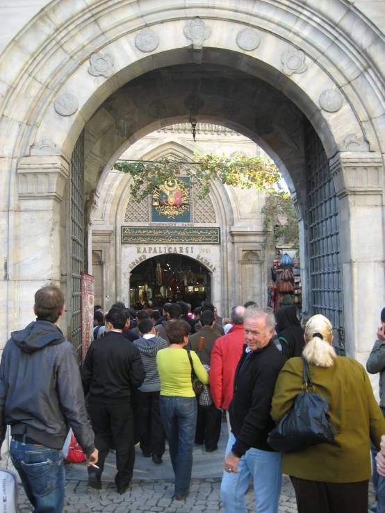 a crowd of people stand under an arch