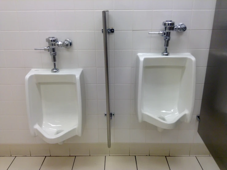 urinals are shown in a bathroom stall, with white tiles on the wall