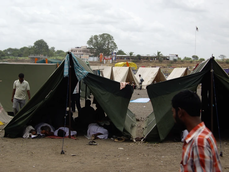 a group of people sitting around tents on the ground