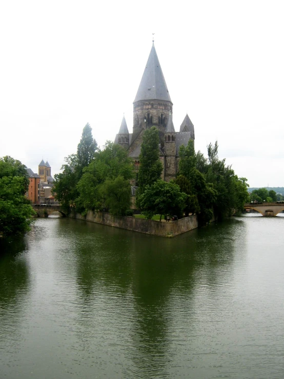 an old castle with a tower by a lake
