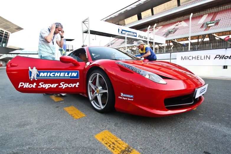 a man stands next to a parked sports car