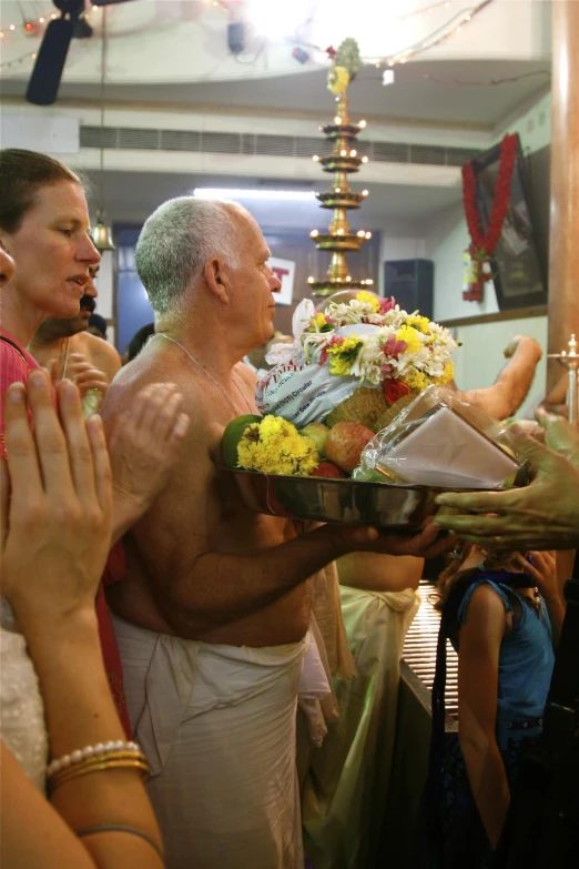 the man is being presented a dish of flowers