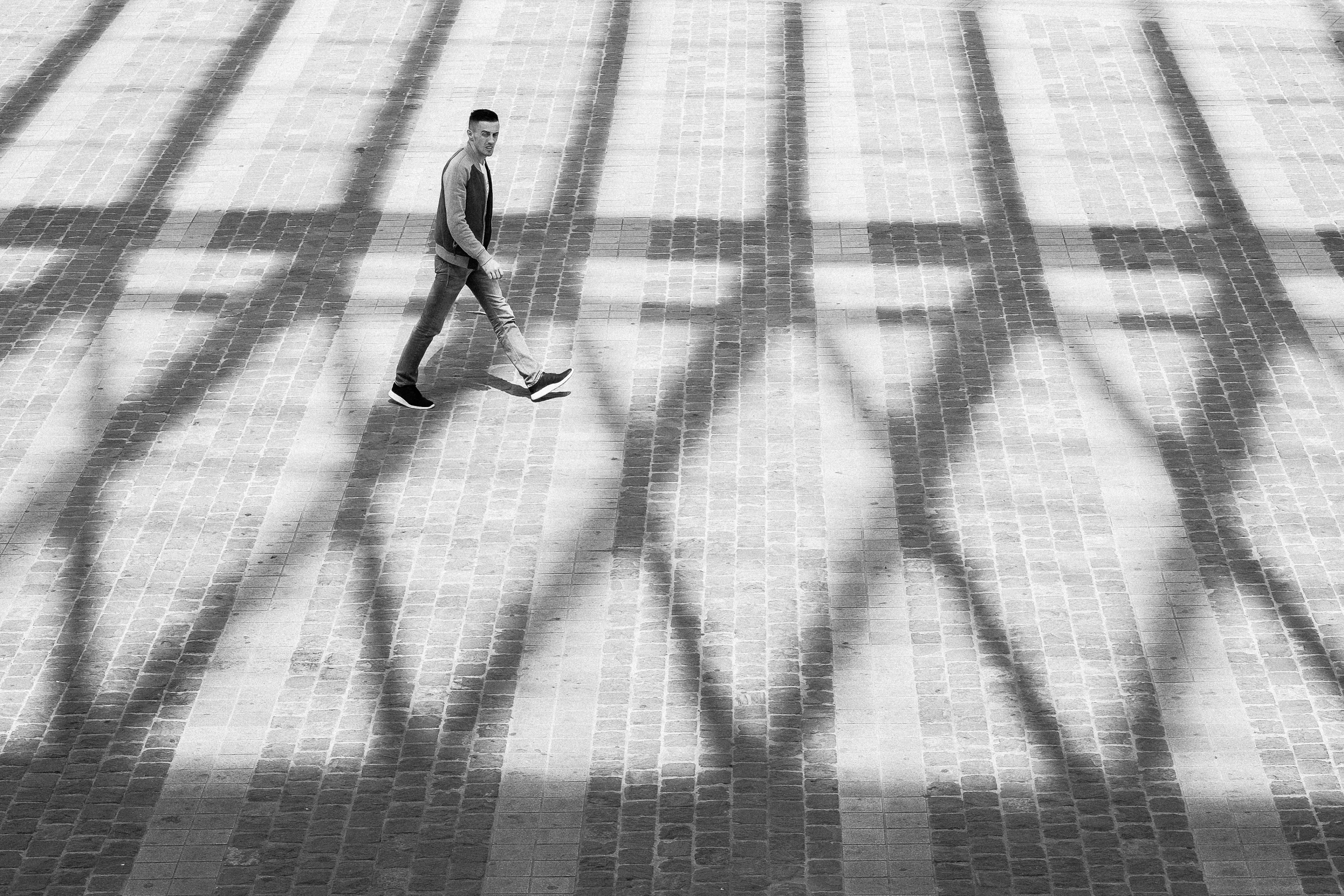 black and white po of man walking in shadow