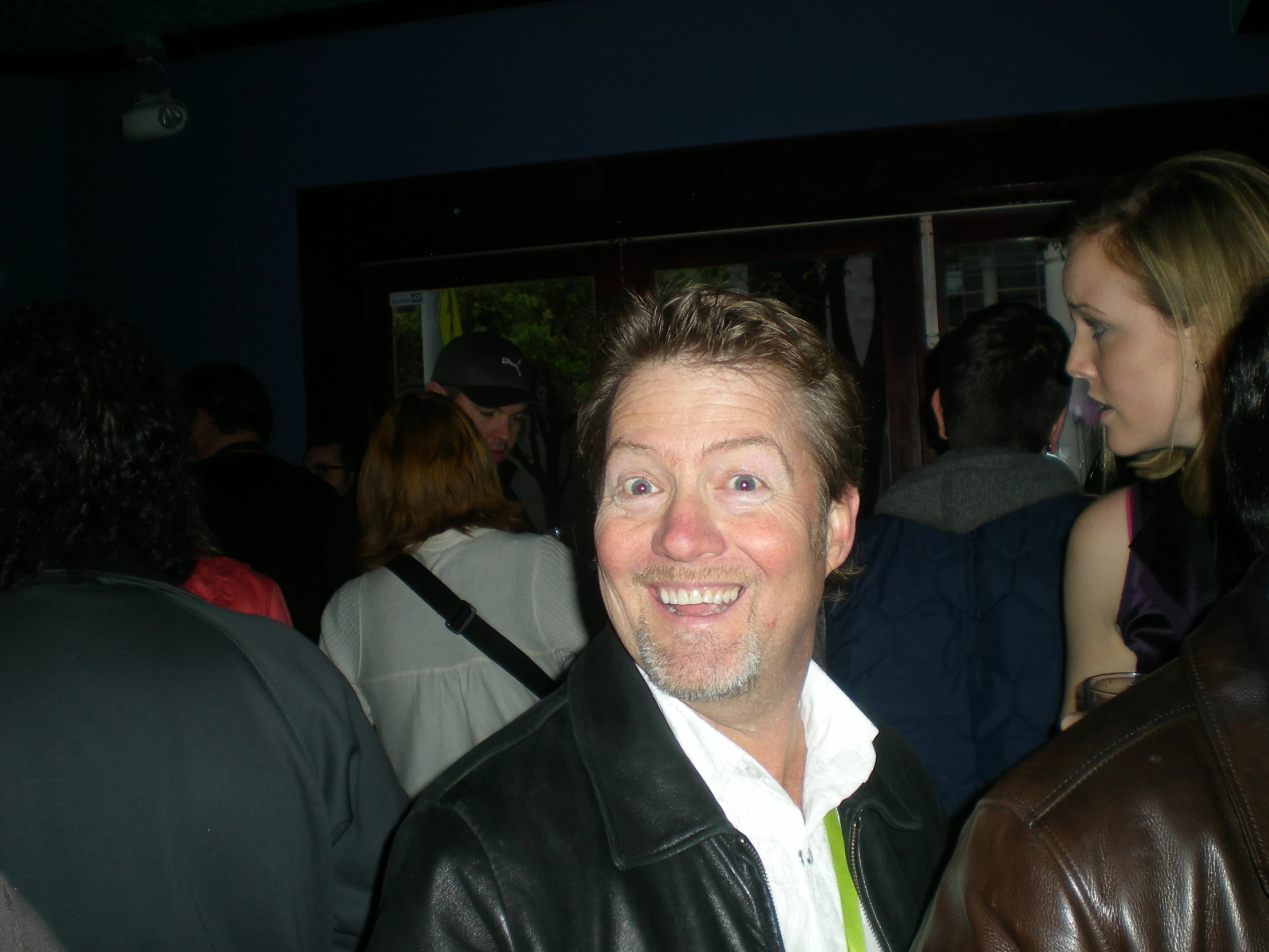 a man smiling while sitting at a table