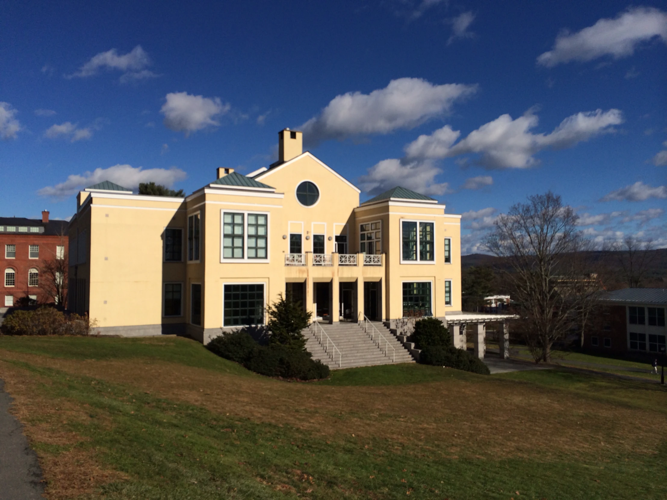 a large yellow house sitting next to a hill