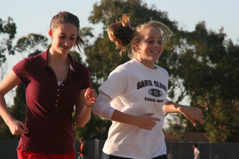 a woman running with another woman looking on