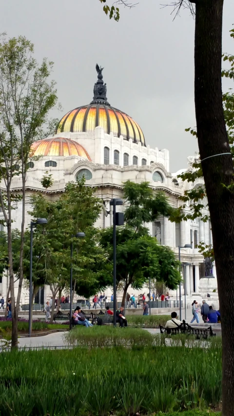 people walking in front of a building with a colorful dome