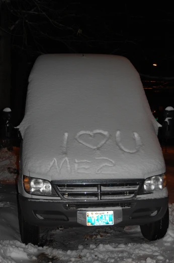 there is a car covered in snow with the name love written on it