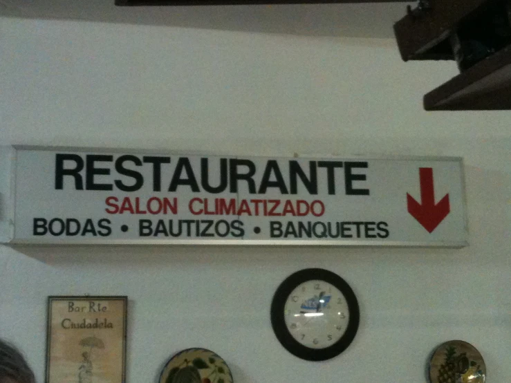 a restaurant sign with a clock is hanging on the wall