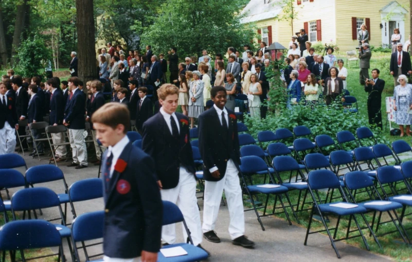group of s in suits and ties standing at the front of a crowd
