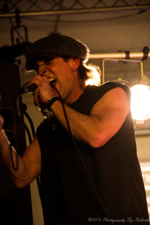 a male singer singing into a microphone while standing