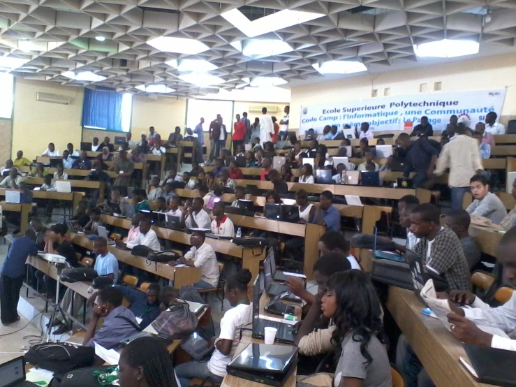 rows of students sitting in their desks with laptop computers