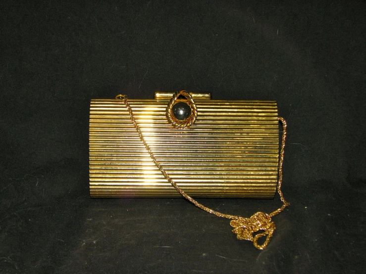 a gold purse with a chain attached