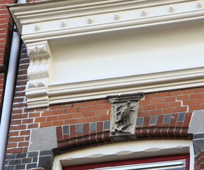 a stone corb hanging on a building with a clock on it